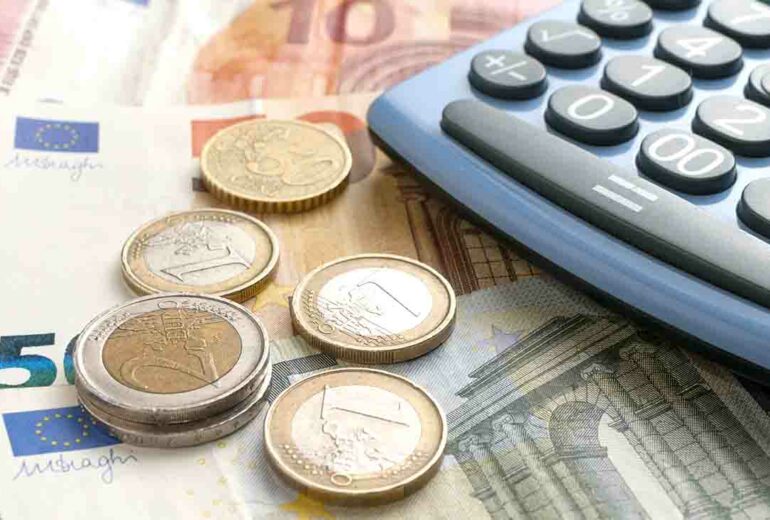 Euro coins on euro banknotes and a calculator